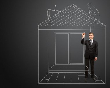 Businessman with marker in fictional house clipart