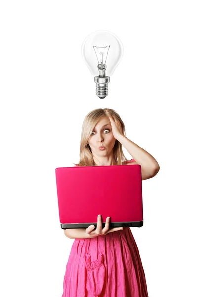 Блондинка в розовом платье с ноутбуком и лампочкой — стоковое фото