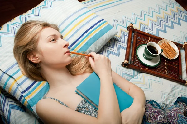 Menina sonhando com xícara de chá e caderno — Fotografia de Stock
