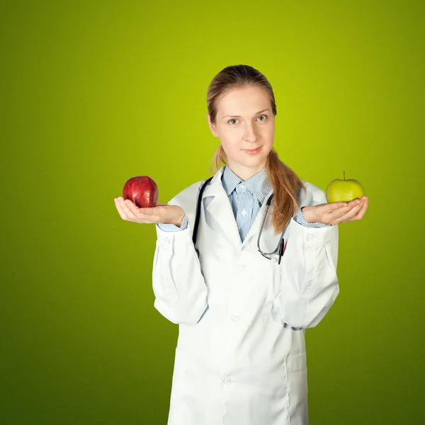 Médico femenino con dos manzanas — Foto de Stock