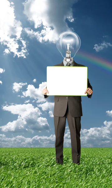 Empresário com cabeça de lâmpada segurando cartão em branco ao ar livre — Fotografia de Stock