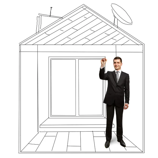 Businessman with marker in fictional house — Stock Photo, Image