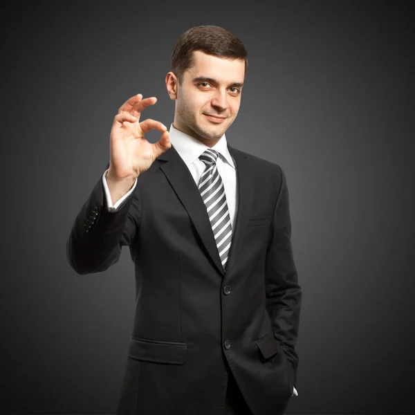 Happy businessman in suit shows OK Stock Picture