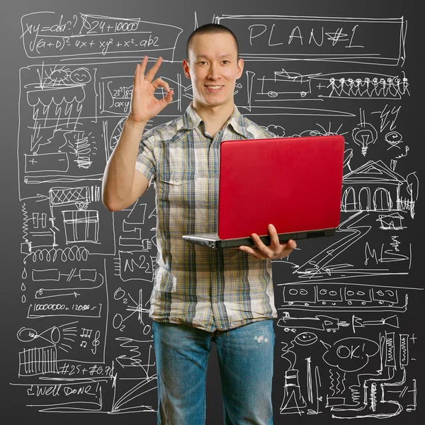 Asian male with laptop in his hands shows OK — Stock Photo, Image