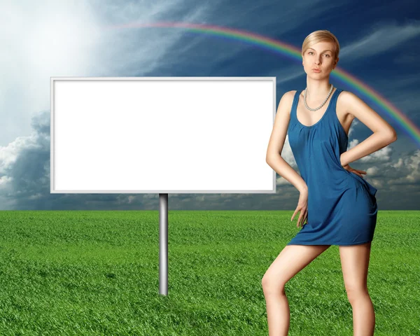 Cartellone pubblicitario e sexy bionda su erba verde e cielo nuvoloso blu — Foto Stock