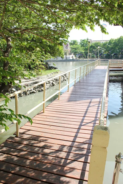 Ξύλινη γέφυρα να διασχίσει ένα ποτάμι σε έναν κήπο — Φωτογραφία Αρχείου
