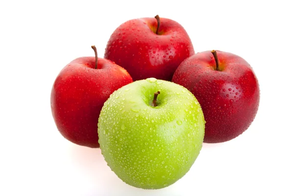 3 красных и 1 зеленый яблоки — стоковое фото
