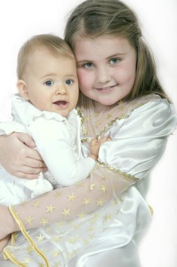 Cute girl holding her little sister in her arms clipart