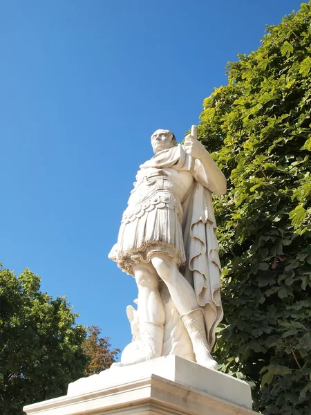 老男人的雕像在法国举行一份文件 在巴黎装饰花园对蓝蓝的天空云和树 — 图库照片