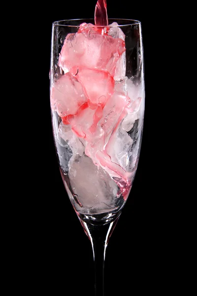 Glas met ijsblokjes wordt gegoten met rode drankje — Stockfoto