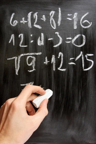 Mano scrive equazioni matematiche sulla lavagna nera — Foto Stock