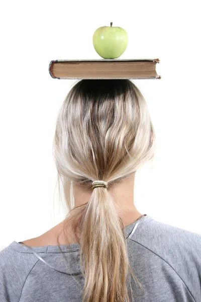 Студент с яблоком и книгой на голове — стоковое фото
