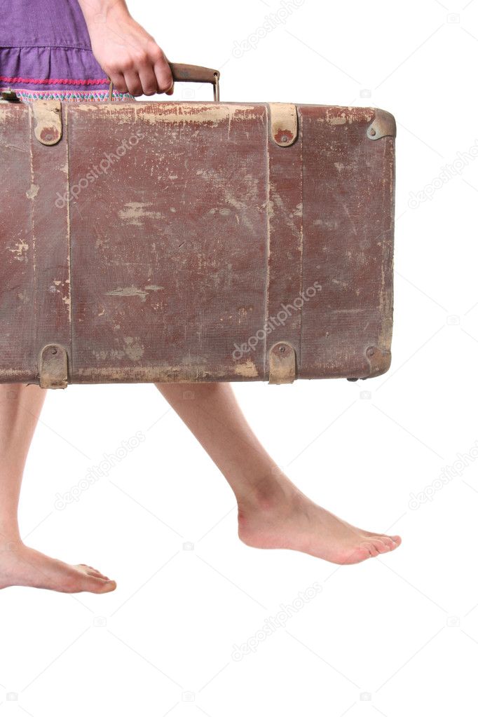 Woman walks with big old suitcase