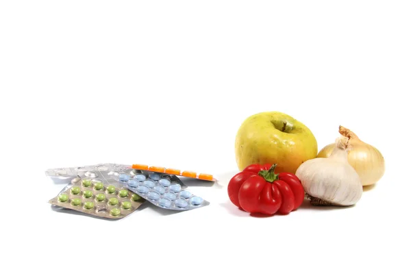 Conceito de alimentação saudável: comprimidos vs vegetais Fotografias De Stock Royalty-Free