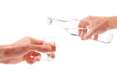 Vodka is being poured into a glass clipart