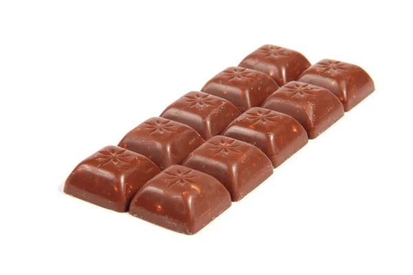 Doces de chocolate em uma fileira isolada no fundo branco — Fotografia de Stock