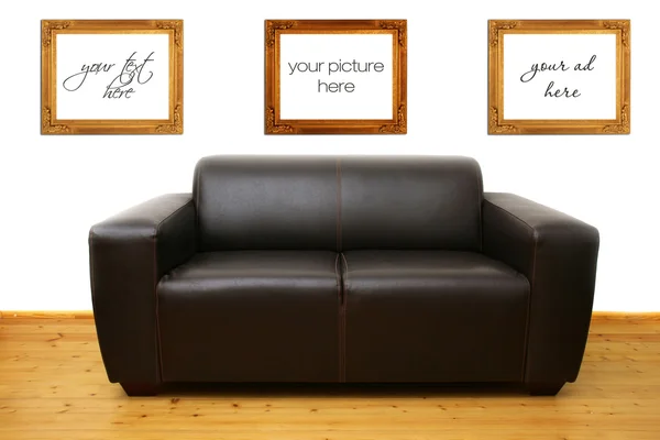 Brown leather sofa and blank photo frames on the wall — Stock Photo, Image