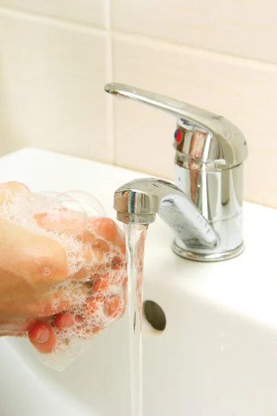 Ręce pokryte mydłem prane w zlewie — Zdjęcie stockowe