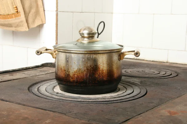 Cooking pot on old kitchen stove — Stock Photo, Image