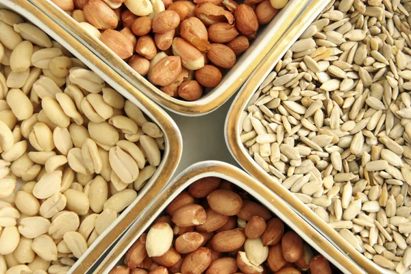 Närbild av behållare med nötter och solrosfrön — Stockfoto