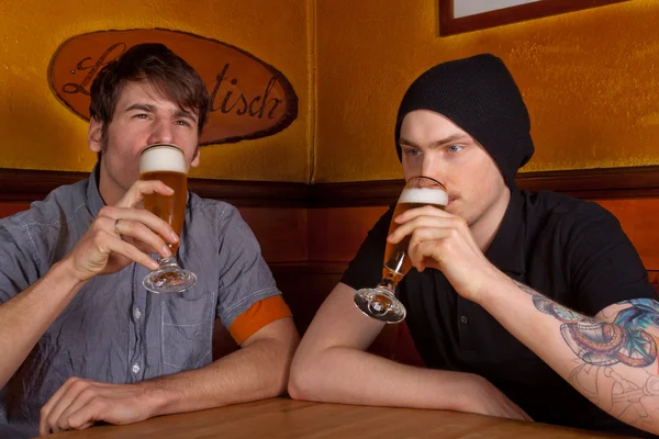 stock image Two friends are sitting in a pub and drinking a beer