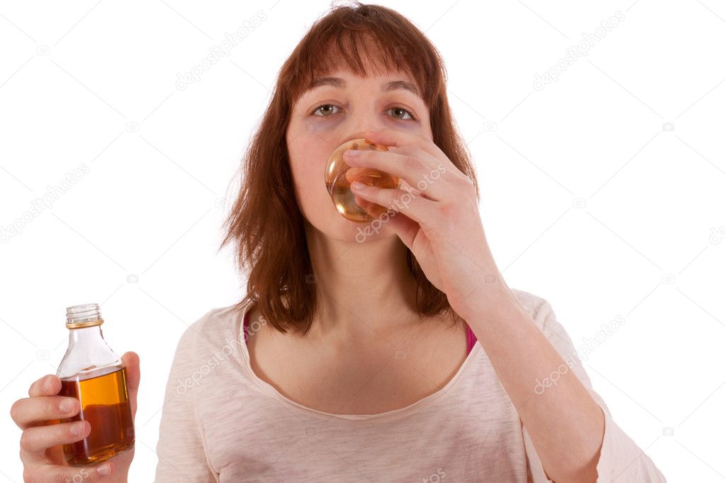 A young woman is drinking hard liquor and has a bottle in her hand