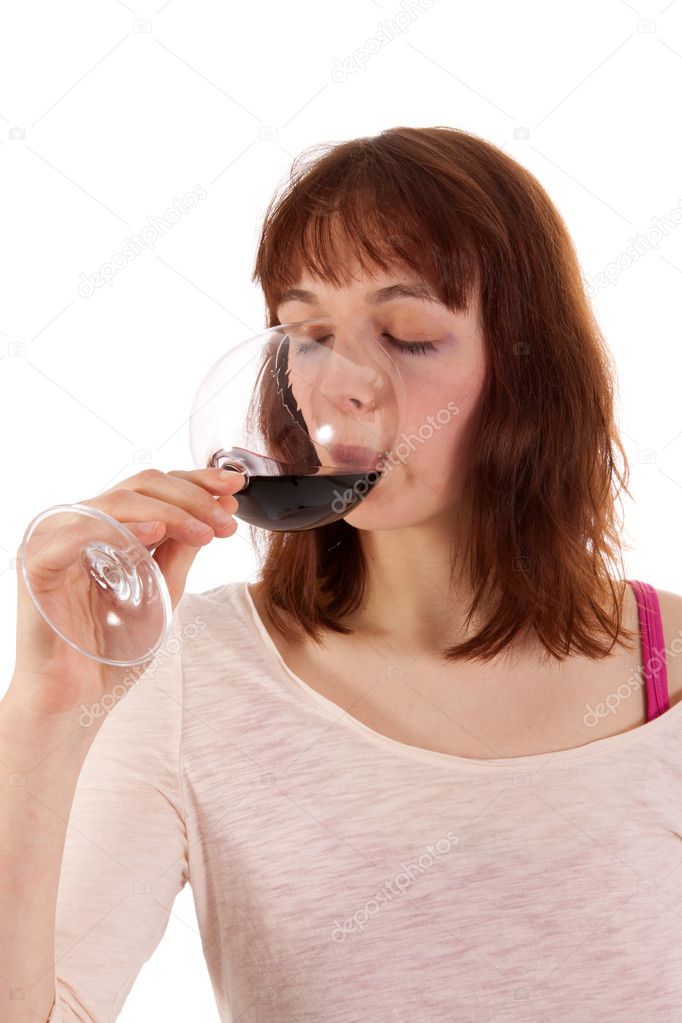 A Young woman is drinking red wine from a glass