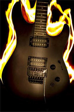 Burn guitar on the black background clipart