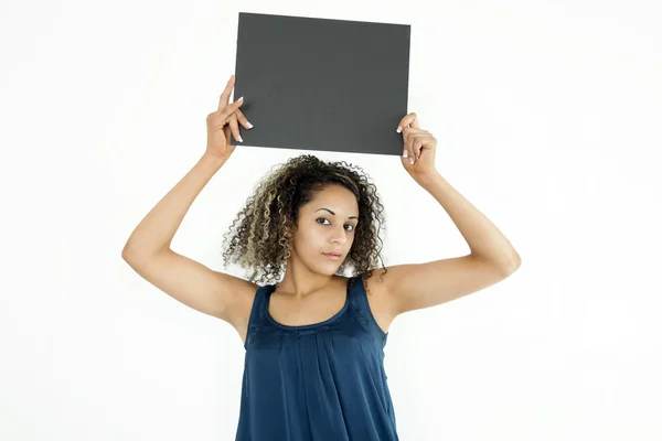 Uma jovem mostrando uma placa cinza em branco — Fotografia de Stock