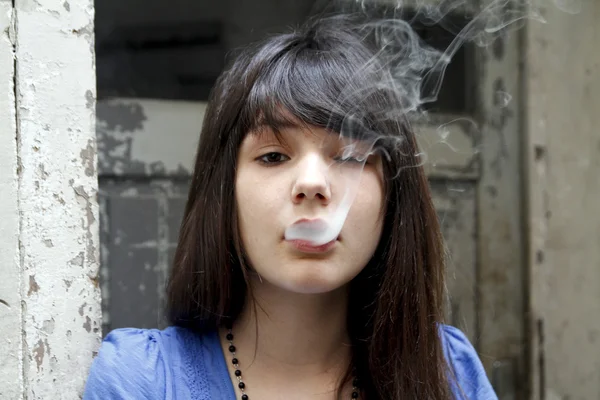 Молодая милая женщина, курит сигарету — стоковое фото