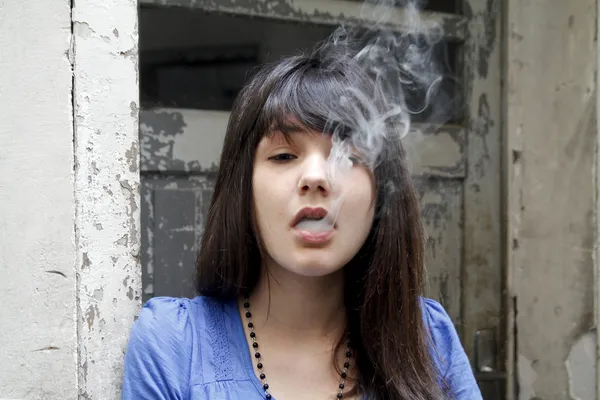 Молода мила жінка, курить сигарету Ліцензійні Стокові Фото