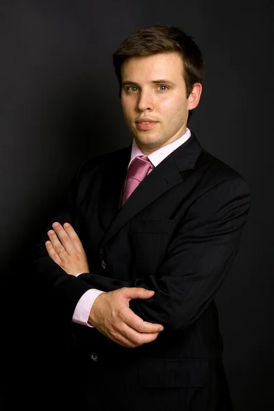 Young businessman portrait on a black background — Stock Photo, Image