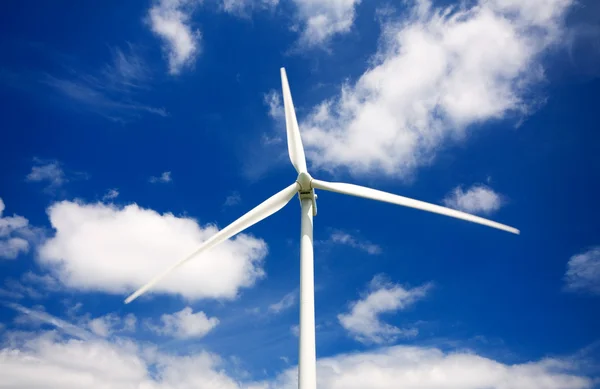 Molino de viento contra un cielo azul y nubes, fuente de energía alternativa —  Fotos de Stock