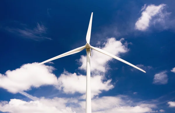 Větrný mlýn proti modré obloze a mraky, alternativní energie energetic — Stock fotografie