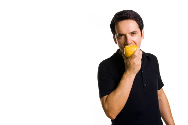 Junger Mann isst einen frischen roten Apfel, isoliert auf weißem Grund — Stockfoto