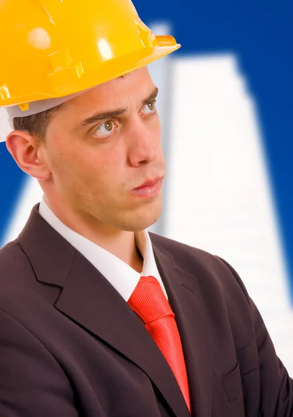 Young architect wearing a protective helmet standing in front of — Stock Photo, Image