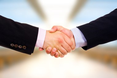 Closeup of business shaking hands at the office clipart