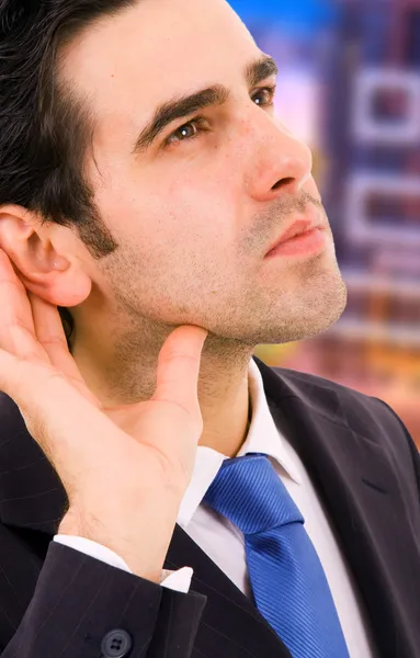 Hombre de negocios joven guapo escuchando la conversación en el de —  Fotos de Stock