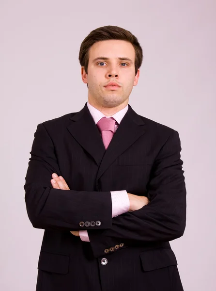 Jovem homem de negócios retrato em um fundo cinza — Fotografia de Stock