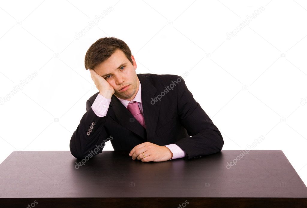 Bored young business man on a desk, isolated on white