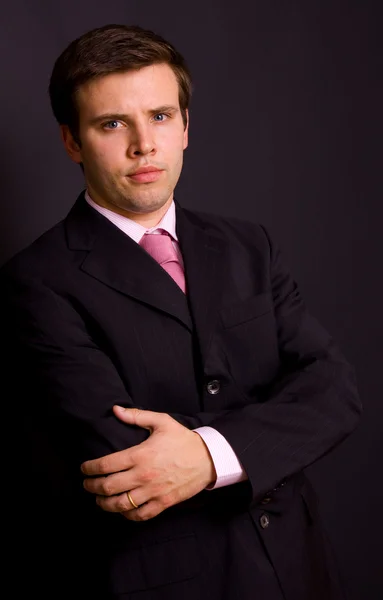 Porträt eines jungen Geschäftsmannes auf schwarzem Hintergrund — Stockfoto