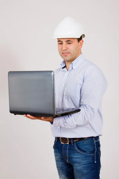 年轻的工程师戴着帽子在笔记本电脑中工作 — 图库照片