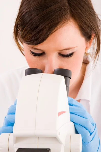Портрет студента-медика, смотрящего через микроскоп в лаборе — стоковое фото