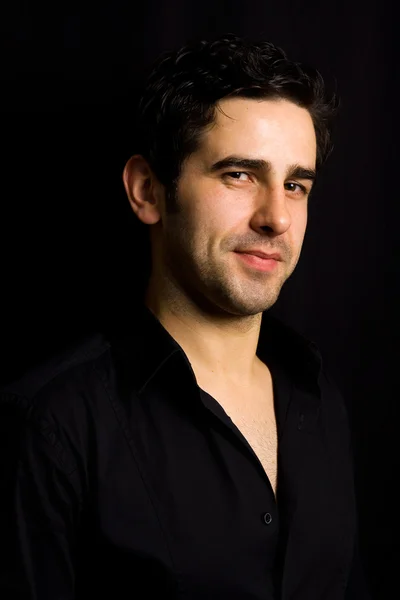 Porträt eines attraktiven jungen Mannes auf schwarzem Hintergrund — Stockfoto