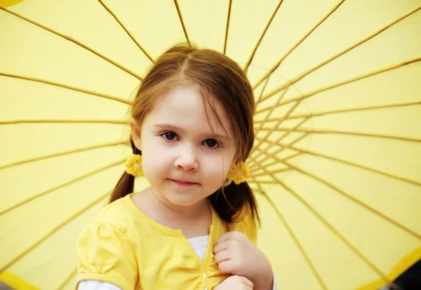 Маленькая девочка с желтым зонтиком — стоковое фото