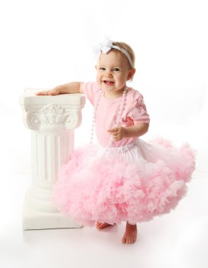 Baby girl wearing pettiskirt tutu and pearls standing next to a clipart