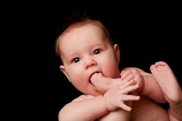 Bebê com dedos dos pés na boca — Fotografia de Stock