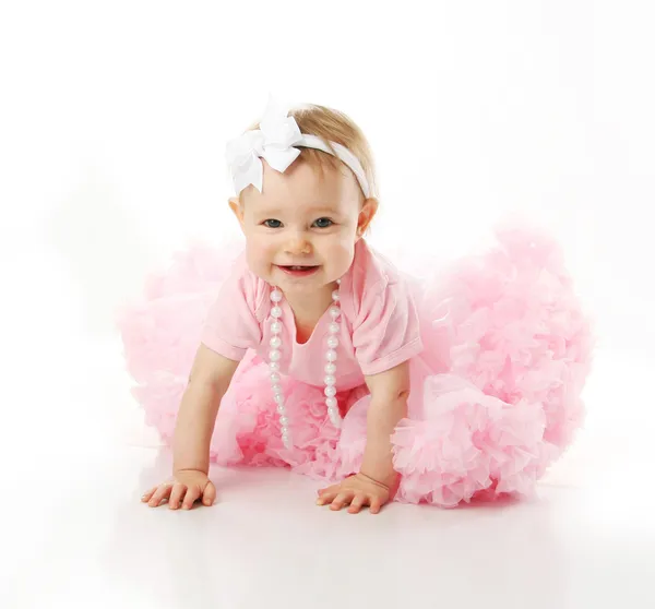 Baby flicka klädd pettiskirt tutu och pärlor kryper Royaltyfria Stockbilder