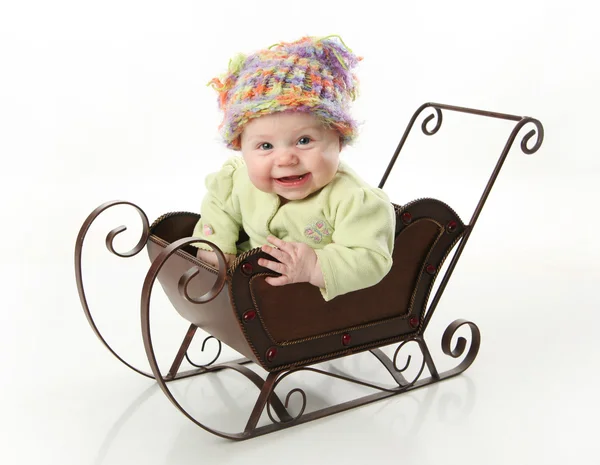 Χαμογελώντας μωρό κάθεται σε ένα έλκηθρο — Φωτογραφία Αρχείου