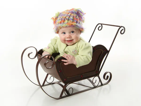 Χαμογελώντας μωρό κάθεται σε ένα έλκηθρο — Φωτογραφία Αρχείου